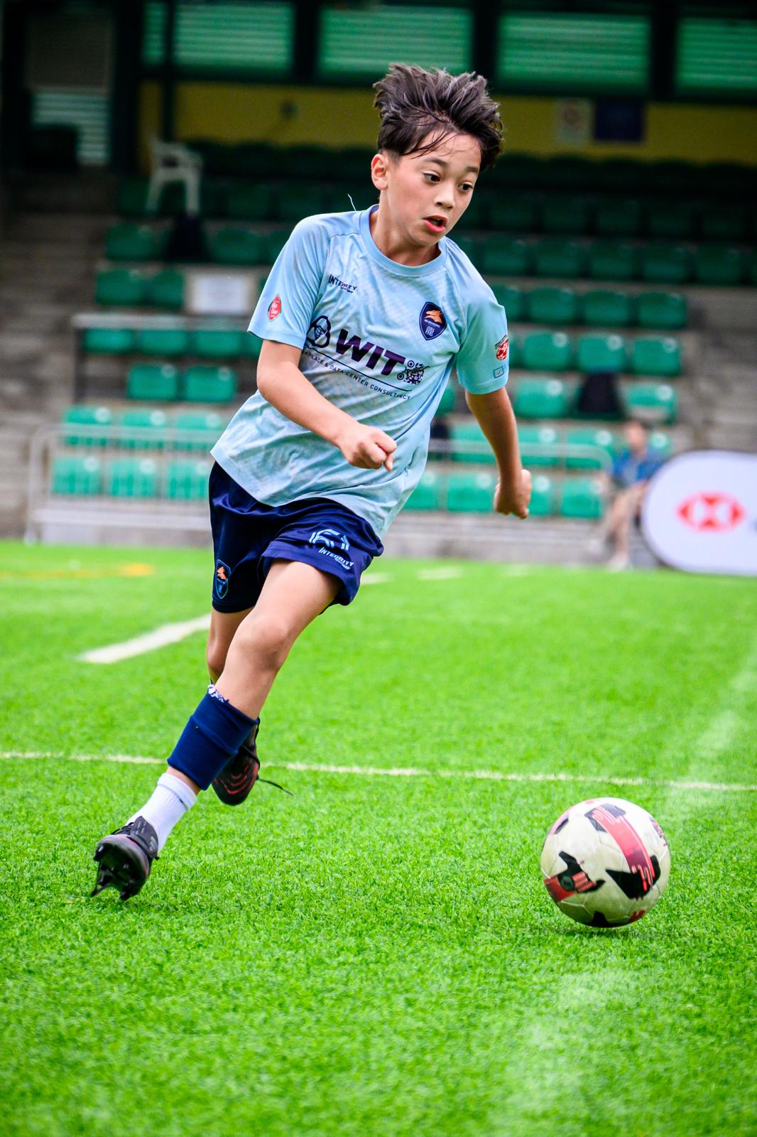A young Dragon striking the ball during a training session