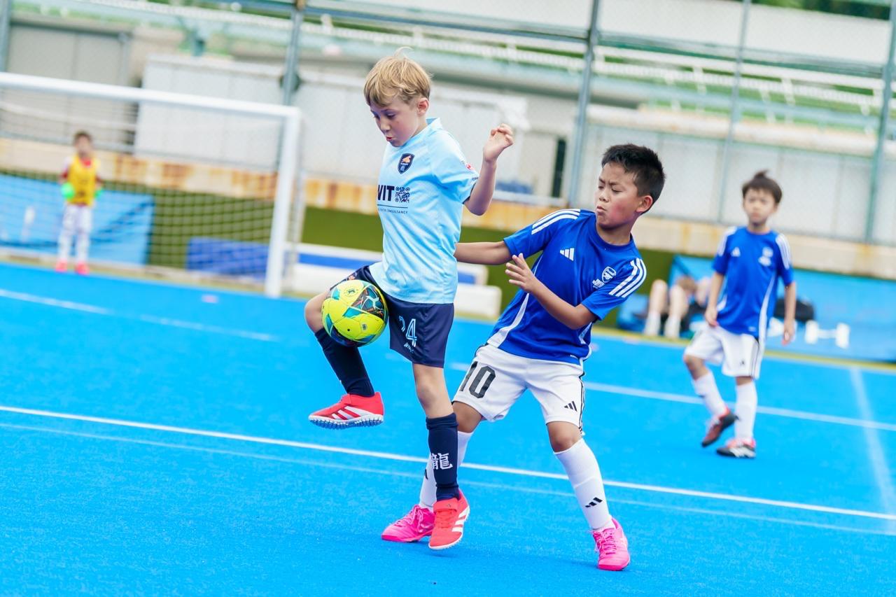 A Dragons player shielding the ball from a defender
