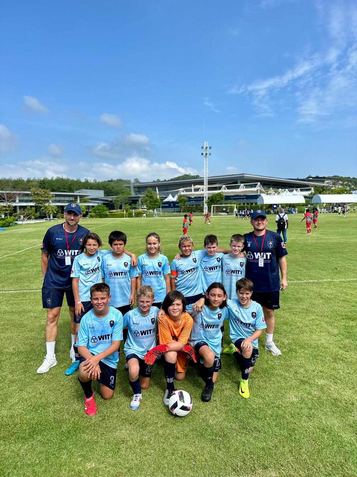 A Dragons team photo on the pitch under a blue sky