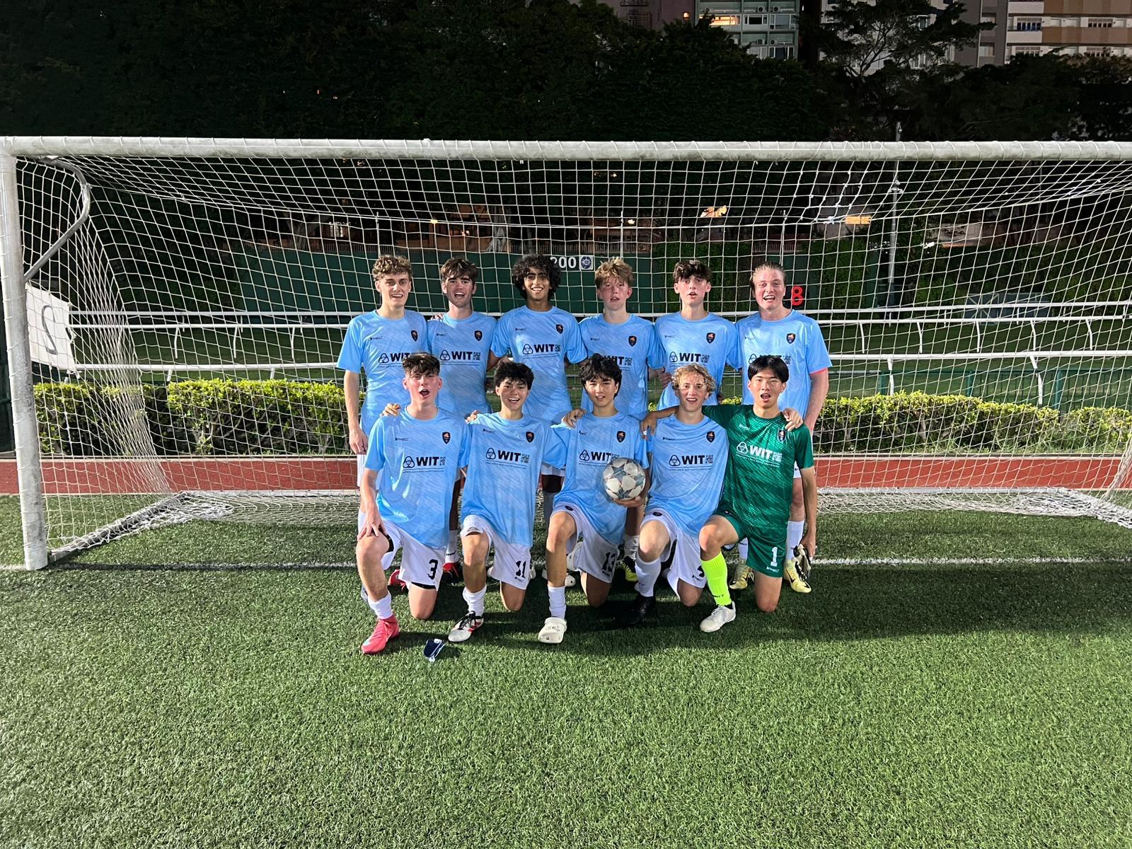 A Dragons team posing together inside the goal
