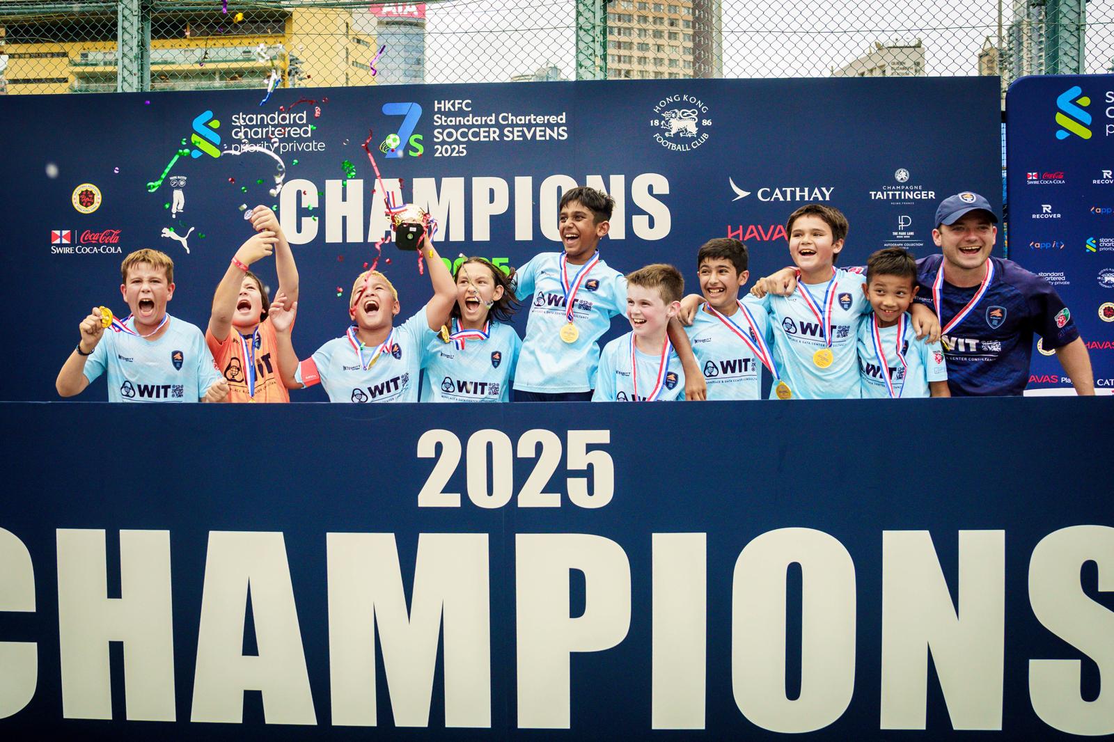 A Dragons squad celebrating in front of the champions board in 2025