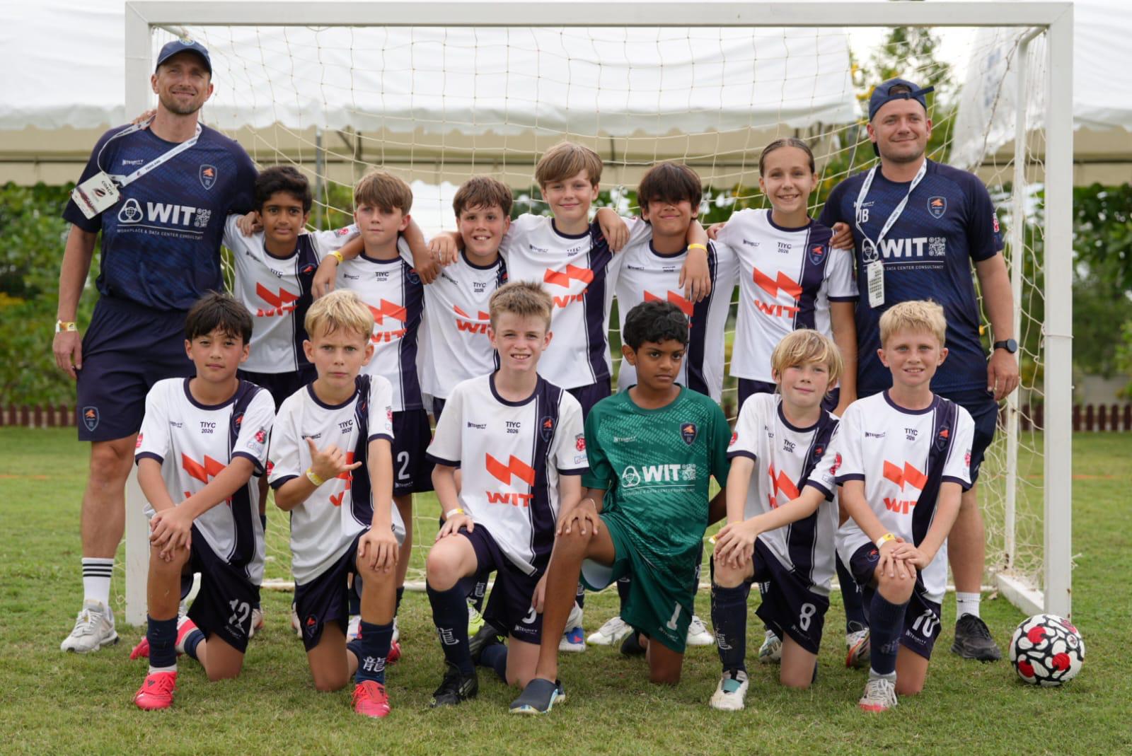A Dragons team lined up in front of goal with their coach