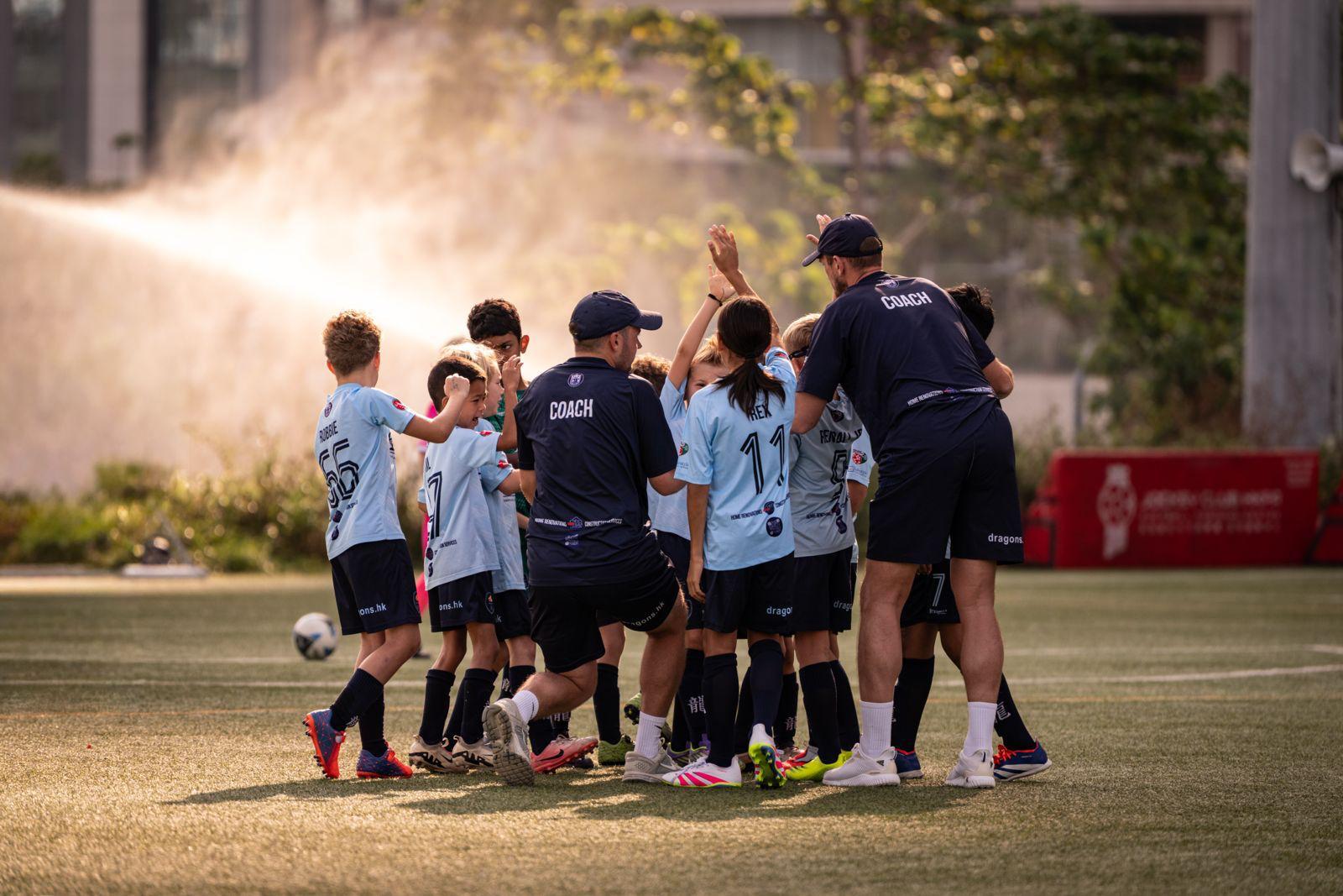 A Dragons team huddling with their coach between matches