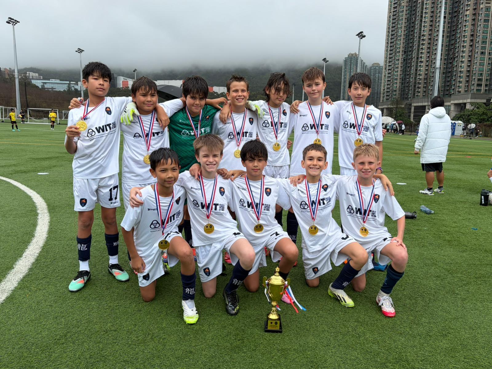 A Dragons squad with their medals and the trophy