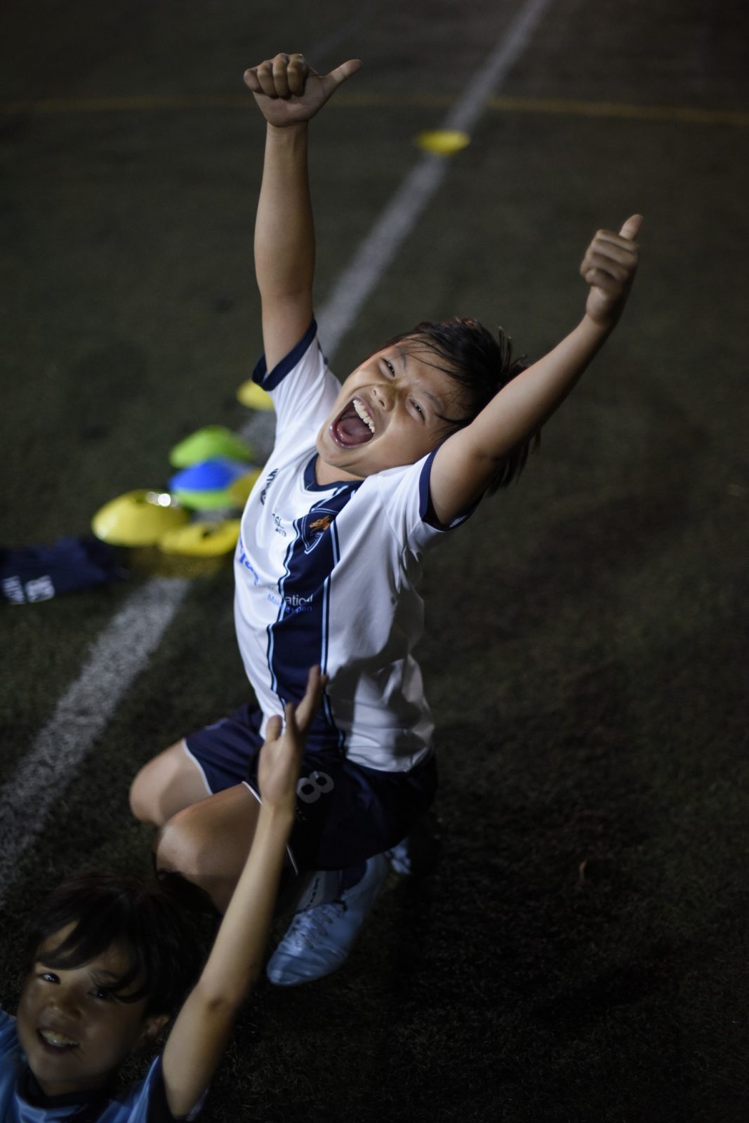 A young Dragon celebrating on the pitch