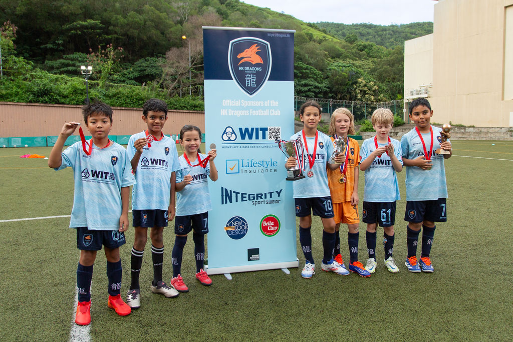 Young Dragons players celebrating with medals and trophies